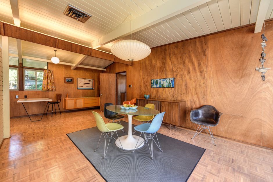 Warm mid-century dining room with pendant light over wood table